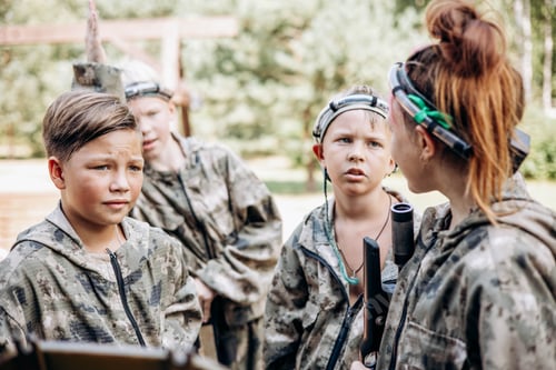 Preview: Group of teenager boy and girl in military uniform standing and waiting laser tag shooting game