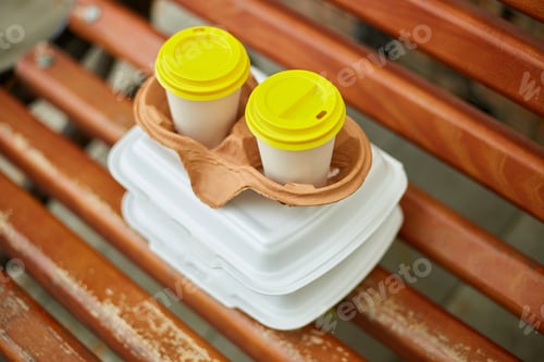 Preview: Paper cups with coffee and fast food boxes to go on a park bench