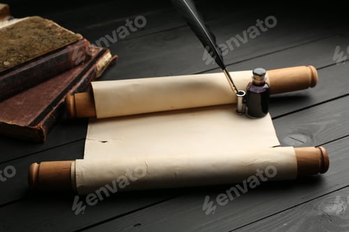 Preview: Old rolled scroll, books, feather and inkwell on black wooden table