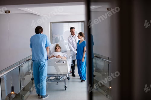 Preview: Team of doctors interacting with each other while examining pregnant woman