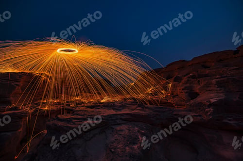 Preview: Sparks & flames long exposure spinning the effect from burning steel wool on the rock