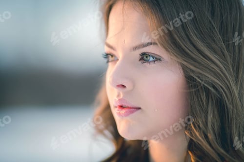 Preview: Portrait of a young female with long brunette hair and green eyes standing outdoors