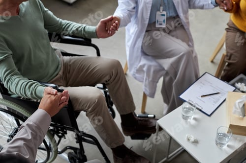 Preview: Elderly people holding hands during support group session