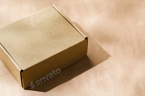 Preview: A plain cardboard box on a textured surface with soft light and shadows during the afternoon