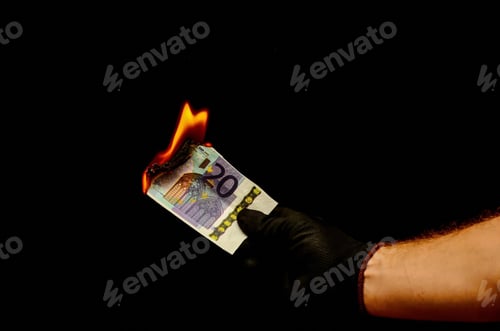 Preview: Closeup shot of a hand burning money on a dark background