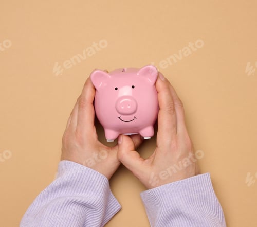 Preview: Female hands hold a pink ceramic piggy bank against a brown background