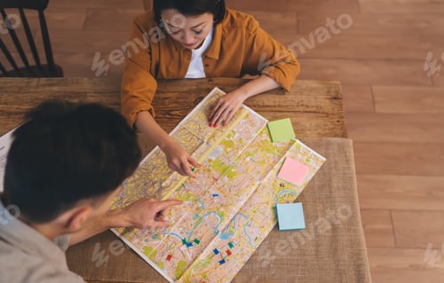 Preview: Сouple choosing famous places on city map at table