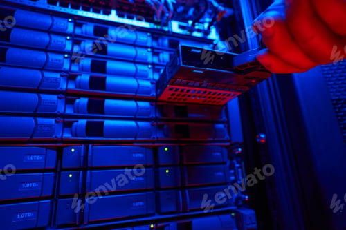 Preview: Server racks with a lot of hard drives and working it engineer with tech equipments