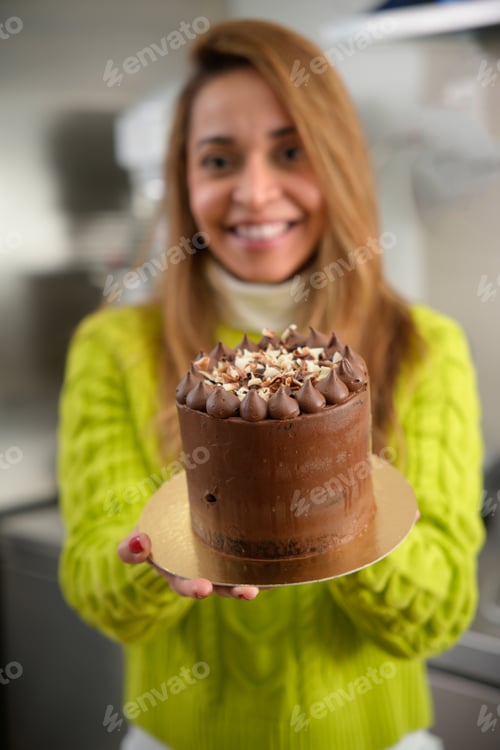 Visualização: mulher latina mostrando um bolo de chocolate na câmera