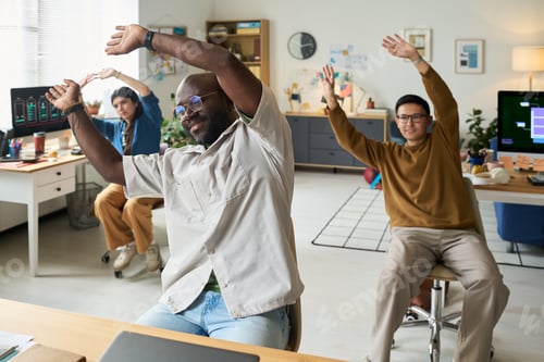 Preview: Multiethnic Adults Performing Seated Stretching Exercises in Office