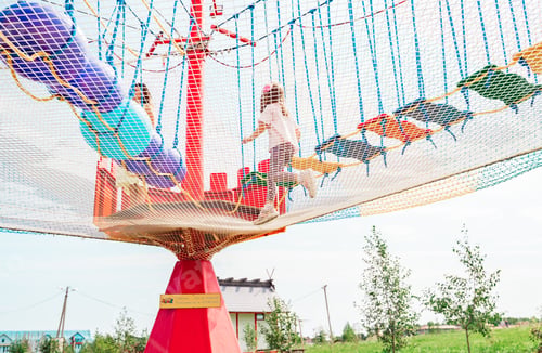 Preview: Small children have fun in rope amusement park. Suspended rides on top. Obstacle course, ladder, ste