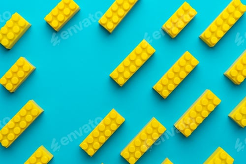 Preview: Yellow Plastic Building Blocks On Turquoise Blue Background With Copy Space