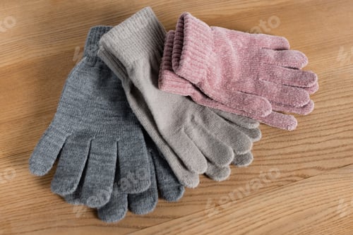 Preview: Top view of cozy gloves on wooden surface