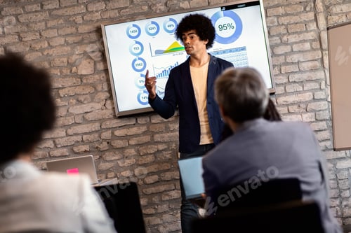 Preview: Businessman holding presentation to diverse group of people.