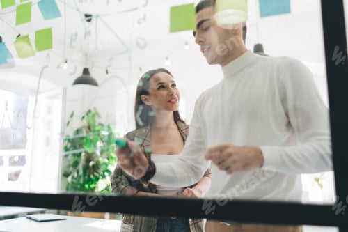 Preview: Cheerful colleagues standing and discussing project in office