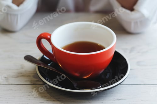 Preview: Red Mug with Dark Tea on Wood Table