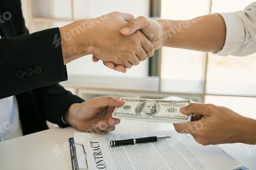 Preview: corporate businessmen shaking hands while one man places money on document