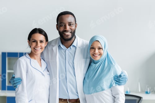 Preview: Cheerful multicultural scientists hugging in laboratory