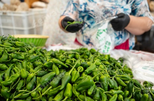 Preview: Gaician woman is selling green padron peppers selling at a fish market in Spain