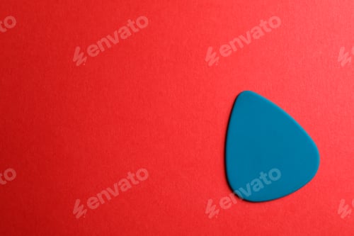 Preview: Blue guitar pick on color background, space for text