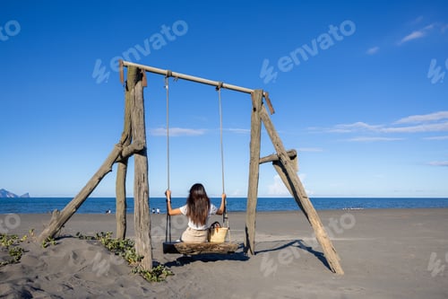 Preview: Woman play with swing on sand beach