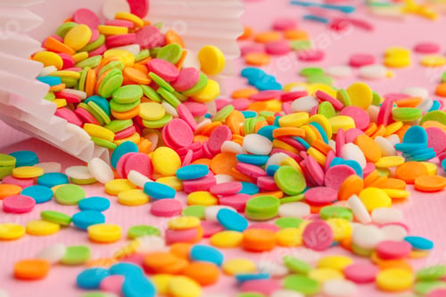 Preview: Sugar sprinkles food background on pink cardboard