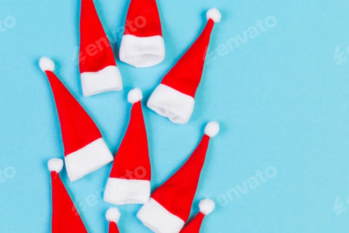 Preview: Top view red Santa hats on colorful background. Time for holiday concept