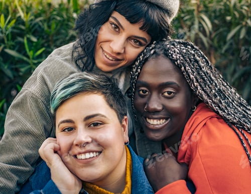 Preview: Happy multi-ethnic friends hugging and smiling in a park