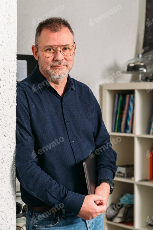 Preview: Businessman standing with laptop