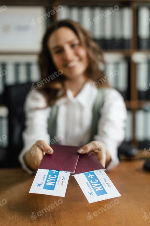 Preview: Close up of young woman holding plane tickets.