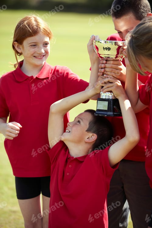 Preview: Children cheering with trophy outdoors