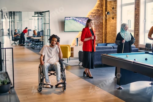 Preview: An African-American young entrepreneur in a wheelchair is surrounded by his business colleagues in a