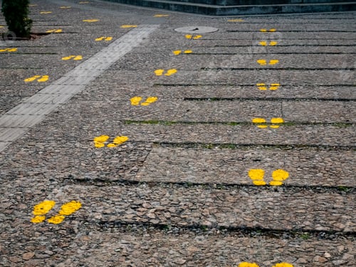 Preview: Shoe Prints Painted Yellow Indicating Social Distancing