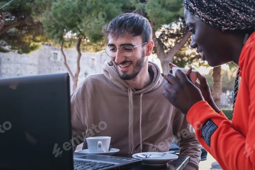 Preview: Biracial couple using laptop at cafe