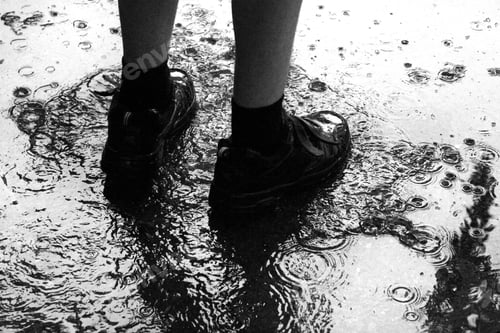 Preview: Boy splashes in a puddle on a rainy day - (Black and white)