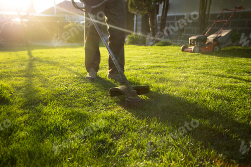 Preview: Garden worker with lawn mover. Garden works in spring.