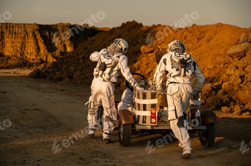 Preview: Astronauts working together on a lunar-like landscape during sunset