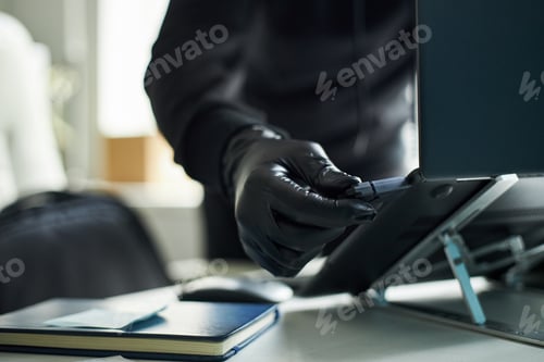 Preview: Anonymous Man Wearing Gloves Inserting Usb Drive into Laptop