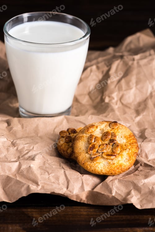 Preview: fresh milk in glass and homemade cookies on baking paper