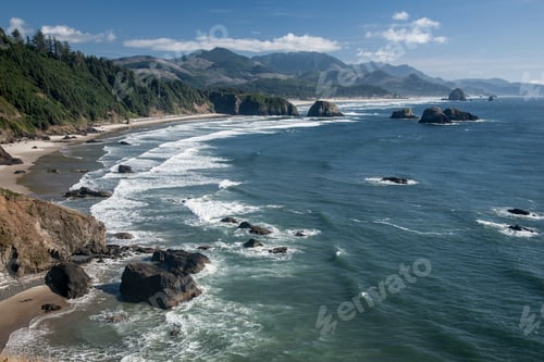 Preview: Cannon Beach with waves breaking on rocky shoreline from above.