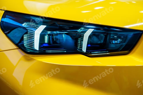 Preview: Close-up of a yellow car s headlights with stunning details.
