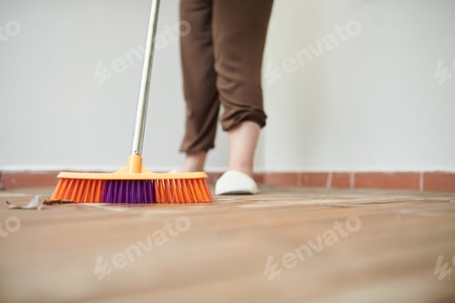 Preview: Woman sweeping floor with mop outdoors