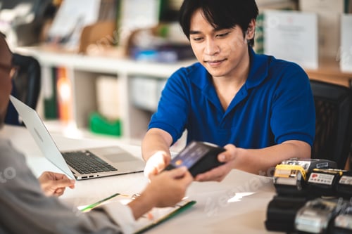 Preview: customer paying for services repair by debit or credit card while salesman holding NFC card machine