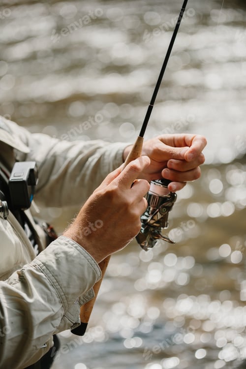 Preview: Fisherman holding fishing rod, waiting for trout to bite