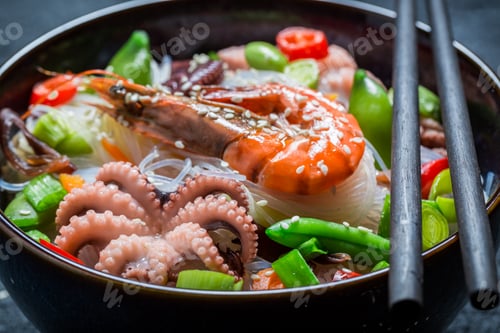 Preview: Tasty seafood noodle in dark bowl with chopsticks