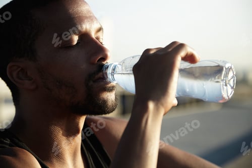 Preview: African American man drinking cold water with eyes closed. Young dark-skinned guy enjoying his bever