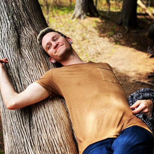 Preview: A handsome young man, laying on an old tree, basking in the setting sun on a crisp fall day.