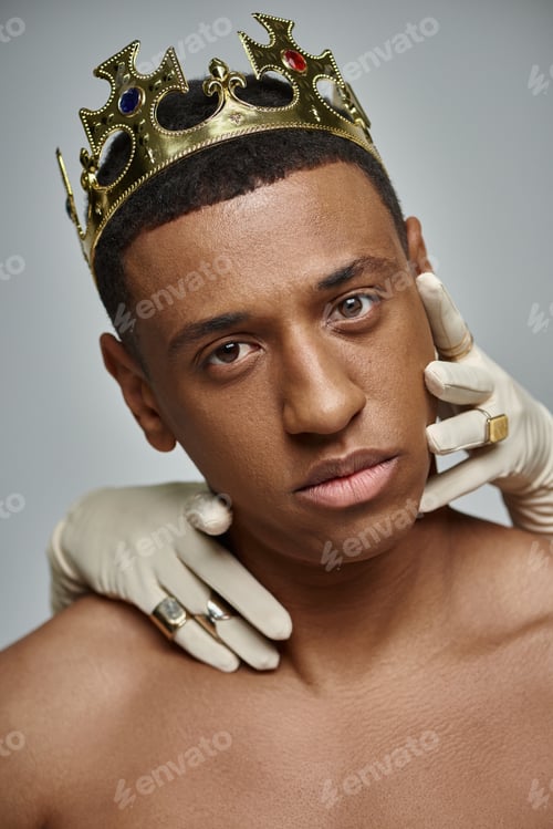 Preview: female hands in white gloves with rings near face of shirtless african american man with crown