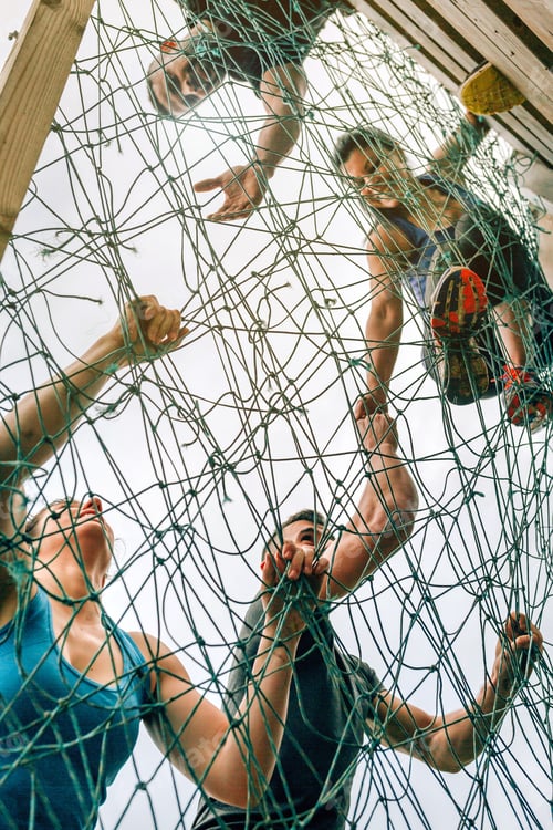 Preview: Participants in obstacle course climbing net