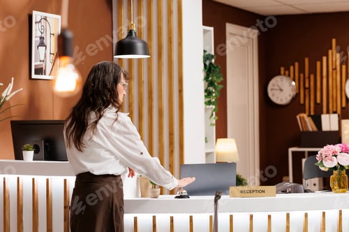 Preview: Woman rings service bell in hotel lobby